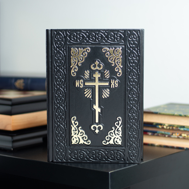 Gift leather book "Bible" with the symbolism of a brass cross on the cover