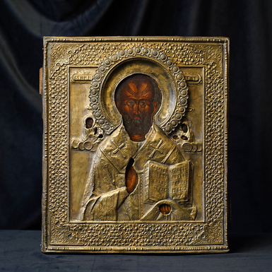 An antique icon in a brass frame of St. Nicholas the Wonderworker from the second half of the 19th century