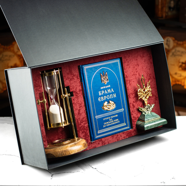 The gift set includes a leather-bound book "Gates of Europe," a vintage hourglass "Royal Compass - 1953," a custom-made figurine of the Coat of Arms of Ukraine, the Trident, and a gift box