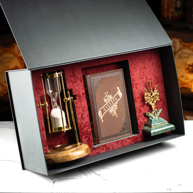 The gift set includes Reprint of the first edition of T. Shevchenko's book "Kobzar", a vintage "Royal Compass - 1953" hourglass, a custom-made figurine of the Coat of Arms of Ukraine, the Trident, and a gift box