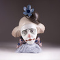 Thoughtful clown in a hat with a flower