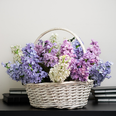 Composition of lilac branches in a white basket