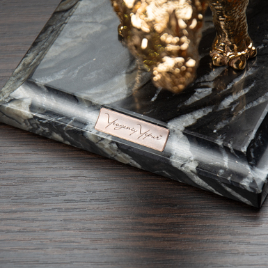 Initials on the pedestal of the statuette photo